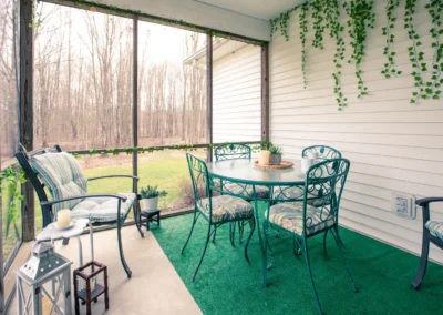 Screened-in porch with a patio table and chairs.