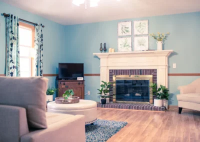living room with blue walls, a fireplace, and a large rug.