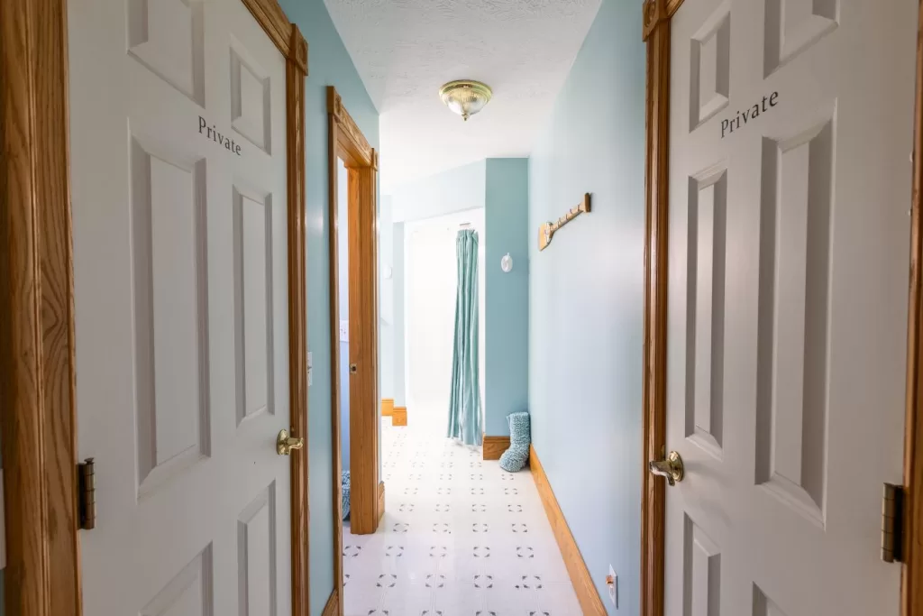 bathroom with blue walls and white counter tops.