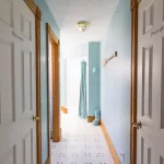 bathroom with blue walls and white counter tops.