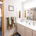 A bathroom with a sink, mirror, and towel rack.