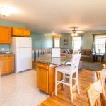 cottage kitchen and living room with a refrigerator and stove.