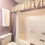  A Serenity bathroom with purple walls and a toilet.